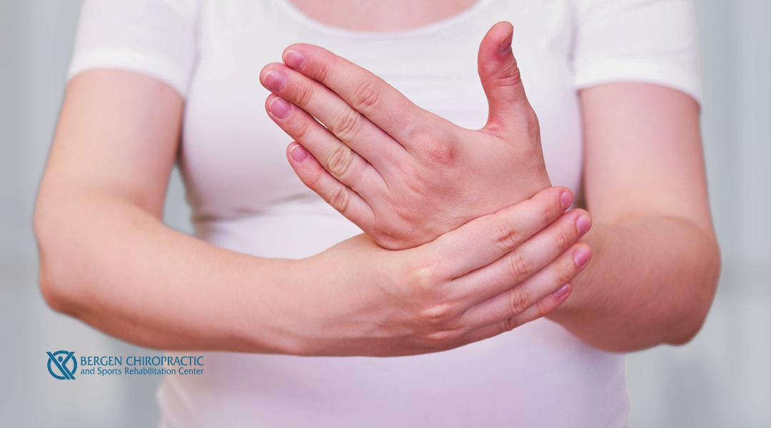A close-up of a woman's hands showing visible swelling as she grasps her painful wrist, highlighting pregnancy-related discomfort.