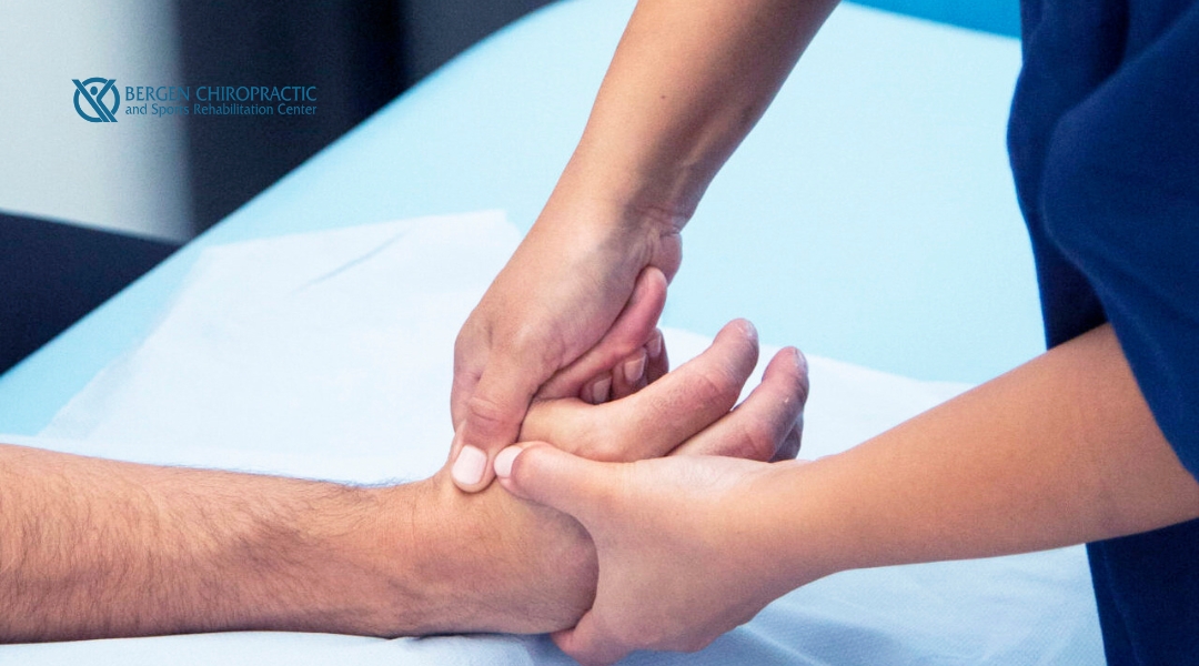 A close-up of a chiropractor performing manual therapy on a patient’s wrist and hand, highlighting precision care at Bergen Chiropractic and Sports Rehabilitation Center.