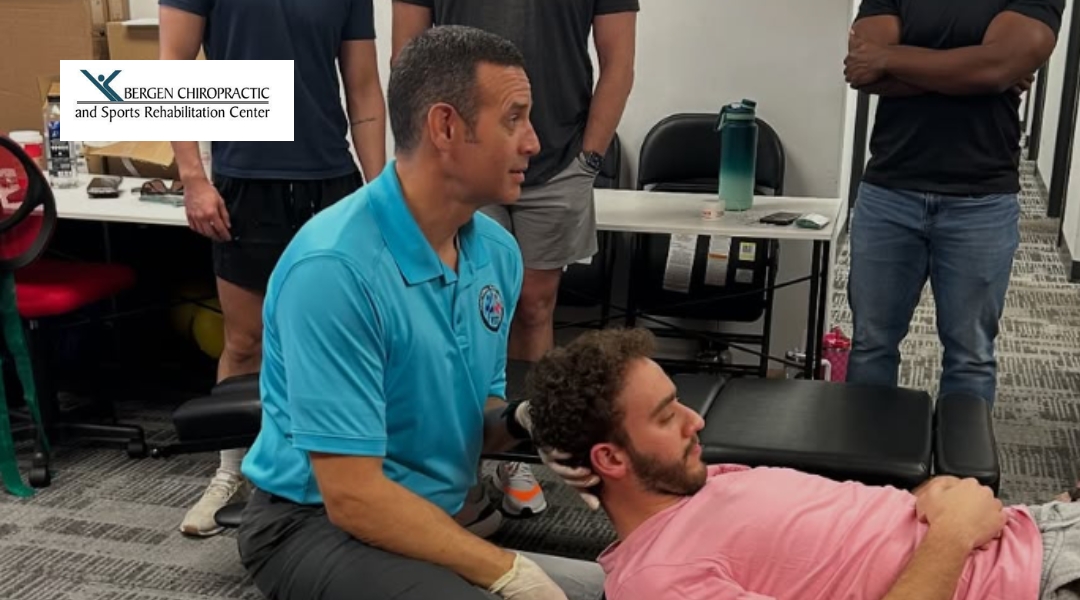A chiropractor at Bergen Chiropractic adjusts a patient's neck with assistance from a colleague in a demonstration setting.
